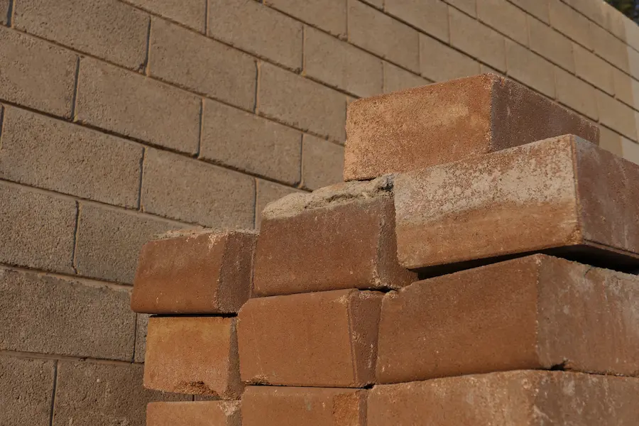 Close-up of bricks stacked against a masonry wall, illustrating cost-effective masonry design.