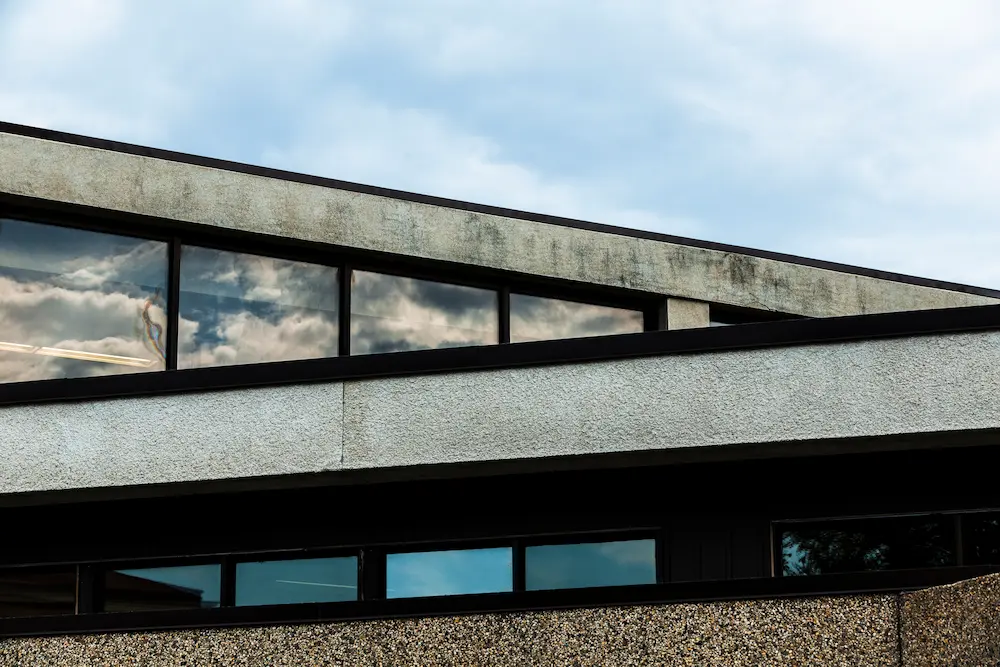 Stone building with a coarse plaster surface, highlighting cost-effective masonry design for budget projects.